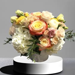 Bouquet of pastel roses and hydrangeas in a white vase