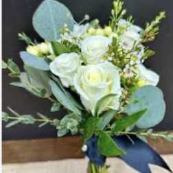 White roses and blue eucalyptus bouquet tied with a navy ribbon