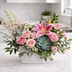 Pink roses and a lily arranged in a white rectangular vase