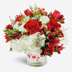 Red roses and white hydrangeas in a clear glass vase