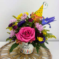 Birthday bouquet in a decorated mug with a party hat pick