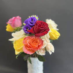 Bouquet of multicolored roses in a white vase