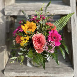 Mixed bouquet with pink and yellow flowers in a striped vase