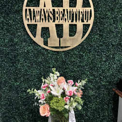 Mixed floral arrangement in a glass vase with peach roses and white lilies