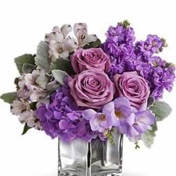 Purple and lavender flower arrangement in a clear glass vase