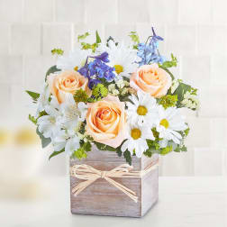Peach roses and white daisies in a rustic wooden box