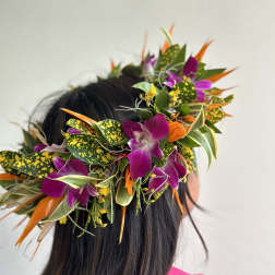 Tropical flower crown with purple orchids and orange accents on a person's head