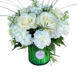 White roses and carnations in a green glass vase