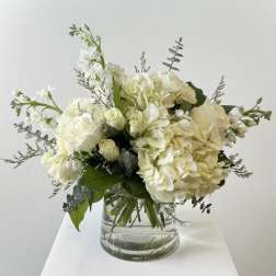 White hydrangea and roses in a clear glass vase