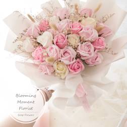 Bouquet of pink and white roses wrapped in pale paper