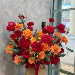 Large bouquet of red and orange roses and gerbera daisies in a box