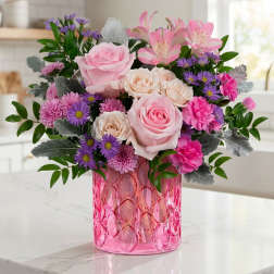 Pink and purple mixed bouquet in a pink glass vase