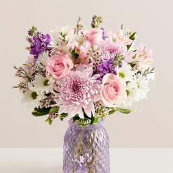 Pink and white mixed bouquet in a purple glass vase
