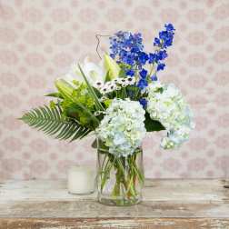Blue and white floral arrangement in a clear glass vase