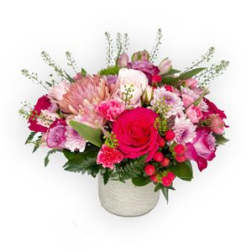 Pink and red mixed flower arrangement in a white vase