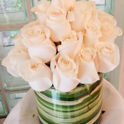 Bouquet of pale cream roses in a striped green vase