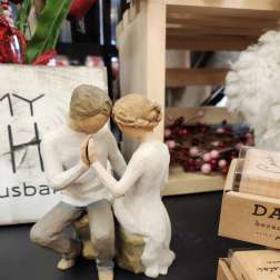 Wooden figurine of a seated couple holding hands