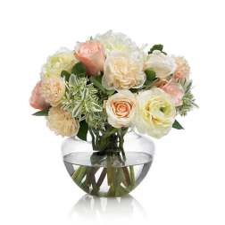 Bouquet of pale roses and cream flowers in a clear glass vase