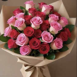 Large bouquet of red and pink roses wrapped in tan paper with a tied ribbon