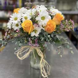 Bouquet of orange roses and white daisies in a glass vase
