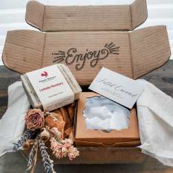 Gift box with soap bars, a candle, and dried flowers
