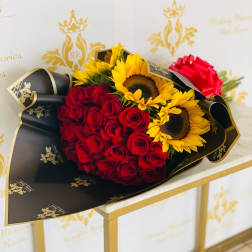 Bouquet of red roses and yellow sunflowers wrapped in black paper