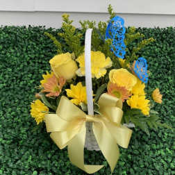Yellow flowers in a white basket with a large bow