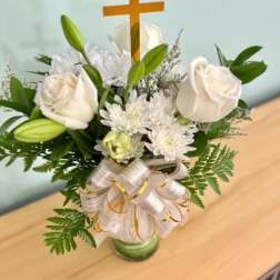 White roses and lilies arranged with a wooden cross