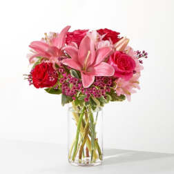 Pink lilies and red roses in a clear glass vase