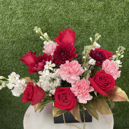 Red roses and pink carnations arranged in a black box