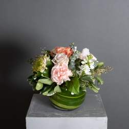 Mixed bouquet in a green glass bowl vase with pink and white flowers
