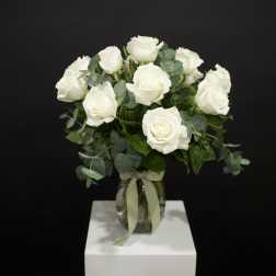 White rose bouquet in a glass vase with ribbon
