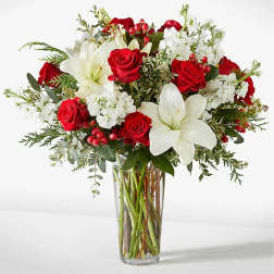 Red roses and white lilies in a clear glass vase