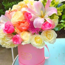 Pink and cream mixed flowers arranged in a pink box