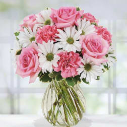 Pink roses and white daisies in a clear glass vase