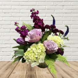 Mixed bouquet with lavender roses, hydrangeas, and purple blooms in a vase