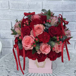 Pink and red rose bouquet in a pink box with ribbon bows