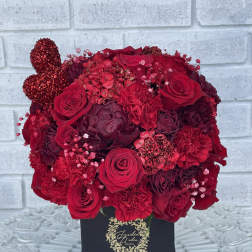 Red rose arrangement in a black box with a glittery heart accent