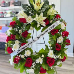 Floral sympathy wreath with red roses and white lilies on a stand