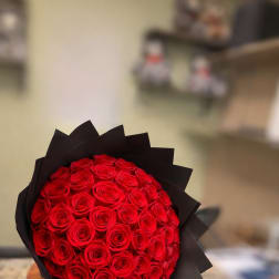 Round bouquet of red roses wrapped in black paper