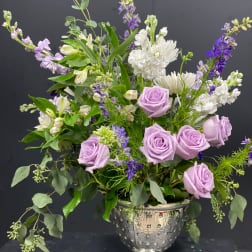 Lavender roses and white flowers in a silver pedestal vase