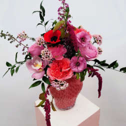 Pink and red mixed bouquet in a textured pink vase