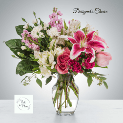 Mixed pink and white flowers arranged in a clear glass vase
