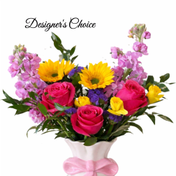 Bright mixed bouquet with pink roses, yellow sunflowers and purple blooms in a white vase with pink bow