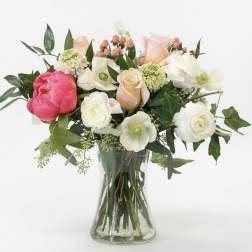 Mixed bouquet of pink and white flowers in a clear glass vase