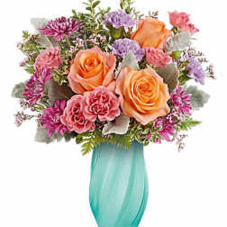Bouquet of peach and pink roses in a turquoise vase