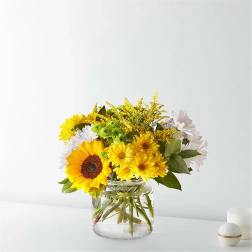 Bouquet of yellow and white flowers in a clear glass vase