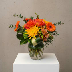 Orange and yellow mixed bouquet in a glass vase