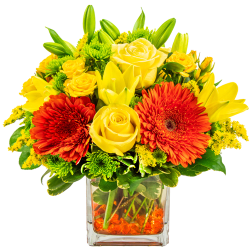 Yellow roses and red gerbera daisies in a clear glass vase