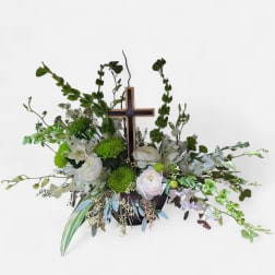 White and green floral arrangement with a wooden cross centerpiece